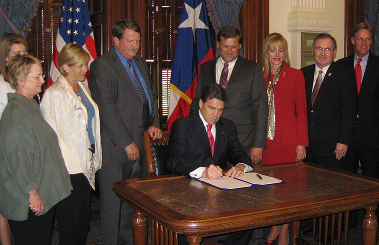 Photograph of Texas Gov. Rick Perry signed the bill granting UH-Clear Lake the authority for downward expansion.